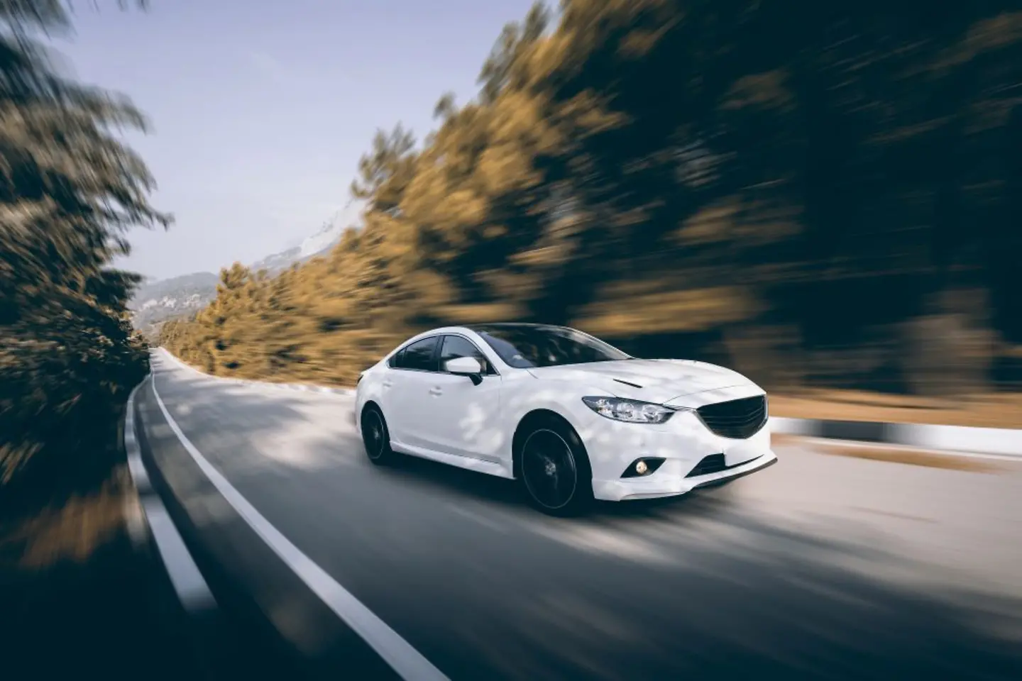 White car driving on a country road