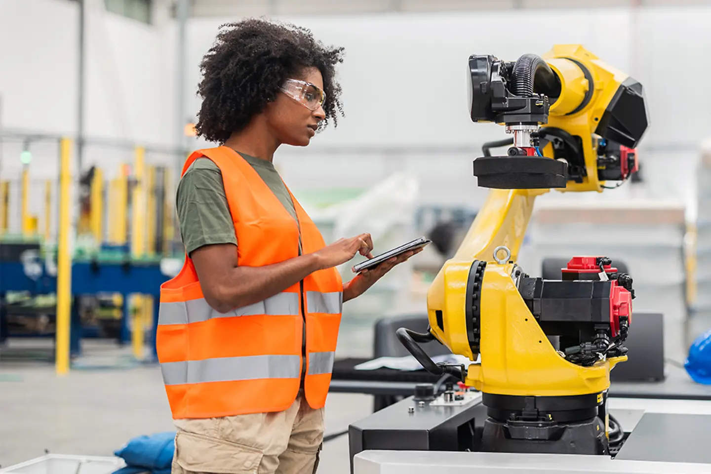 Une ingénieure programme des robots d’usine