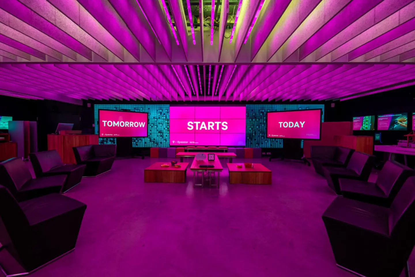 Innovation Center München mit Bildschirmen, Tischen und Stühlen