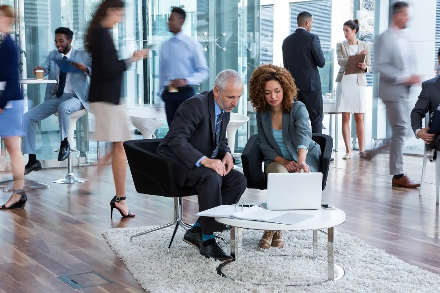 Des hommes d’affaires discutent de la transformation des données à une table sur laquelle est posé un ordinateur portable.