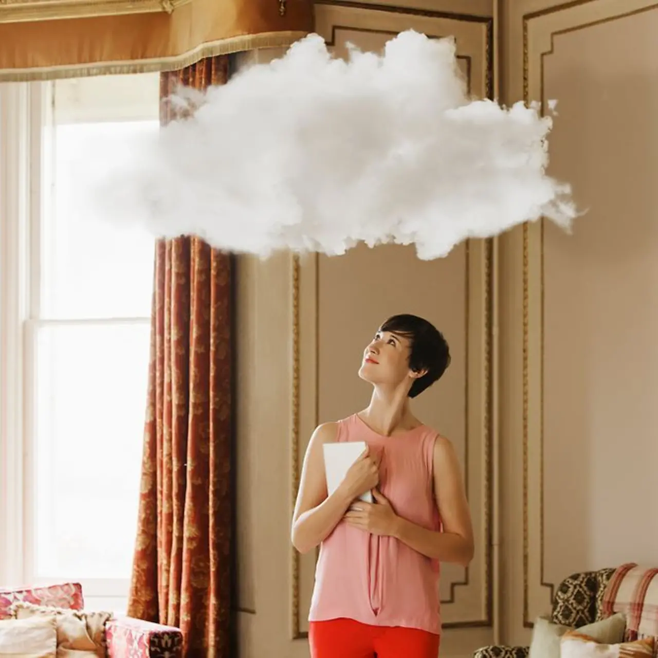 Mujer con laptop mirando una nube sobre su cabeza